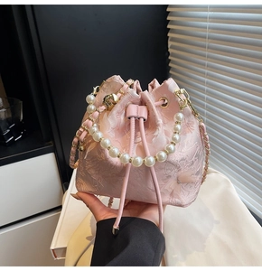 Detail of pink bucket bag with 3D butterflies and elegant pearl handle strap