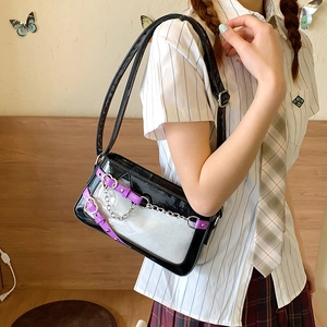 Détail du sac à bandoulière noir et blanc avec chaîne argentée et boucle cœur