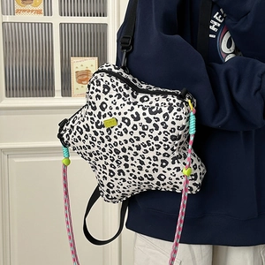 Star-shaped crossbody bag with leopard print and vibrant woven rope details on model