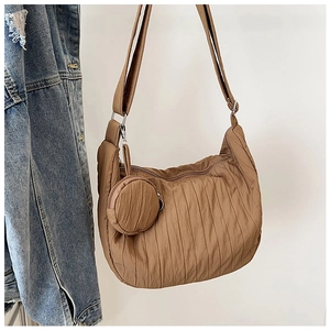 Detailed view of brown pleated hobo bag with adjustable strap and small round coin purse
