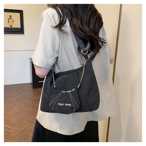 Detail of black canvas tote bag with removable cat-shaped coin purse and wide strap