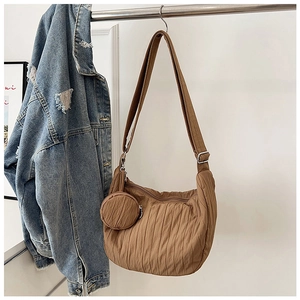 Detail of a brown pleated crescent bag with a matching detachable round coin purse charm