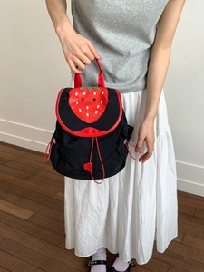Cute black nylon backpack featuring a vibrant red strawberry flap and drawstrings