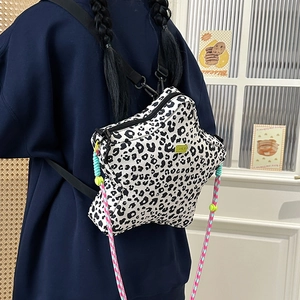 Detail of star-shaped leopard print backpack with colorful rope and metal logo