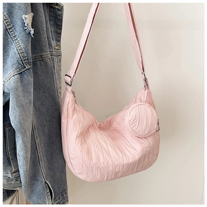 Detail of light pink pleated hobo bag with adjustable strap and small coin purse charm