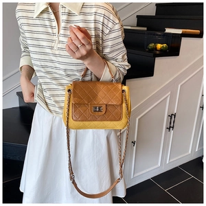 Detail of yellow quilted leather bag with brown flap and silver twist lock closure