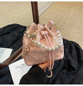 Close-up of pink lace bucket bag with 3D floral embroidery and elegant pearl handle