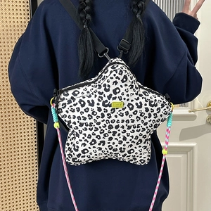 Detail of star-shaped leopard print backpack with colorful rope straps and green logo