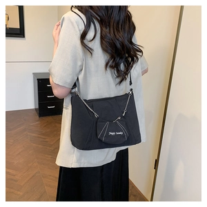 Detail of black canvas tote bag with Happy Sunday coin purse and metal chain strap