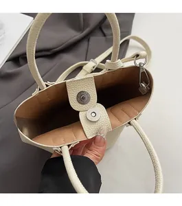 Top view of beige bucket bag showing magnetic closure and brown interior lining detail