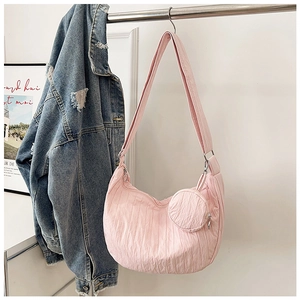 Close-up of pink hobo bag featuring crinkled texture and detachable mini coin purse