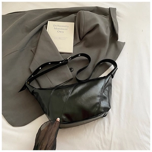 Détails du sac demi-lune noir avec coutures diagonales et boucle en métal argenté