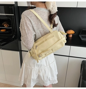 Detail of light yellow pillow bag with adjustable strap in modern home setting