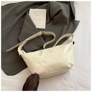 Détail du sac bandoulière blanc crème avec texture en similicuir et coutures diagonales