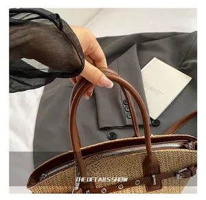 Detail show of woven straw handbag featuring leather handles and silver zipper closure