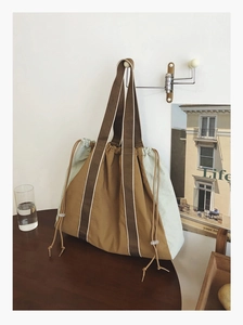 Detail of khaki canvas tote bag with mint green sides and drawstring closure