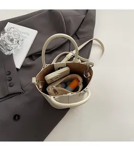 Interior view showing the large capacity of a cream white leather bucket bag with silver clasp