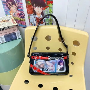 Détail du sac ita en cuir verni noir avec fenêtre transparente, boucle rouge et chaînes