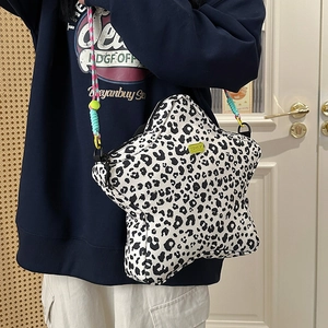 Detail of star-shaped crossbody bag with leopard print and colorful woven strap