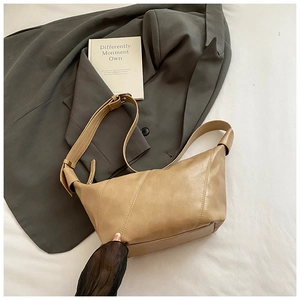 Détail du sac demi-lune kaki avec surpiqûres décoratives et bandoulière réglable
