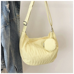 Detail of pale yellow pleated nylon dumpling bag with matching circular coin purse charm