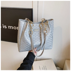 Détail du sac cabas bleu clair avec imprimé monogramme et anse en chaîne dorée