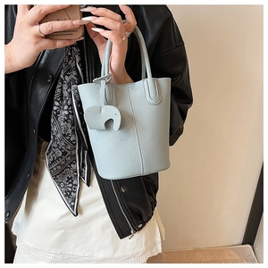 Detail of light blue lychee pattern mini bucket bag with leather elephant charm