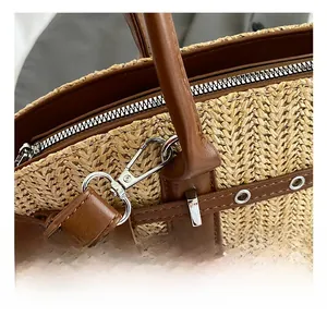Close-up of high-quality silver metal hooks and premium stitching on a straw tote bag