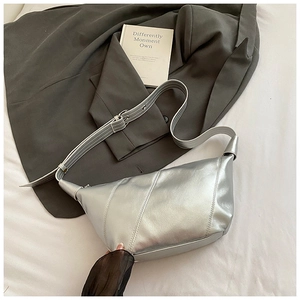 Détail du sac demi-lune argenté avec surpiqûres obliques et bandoulière réglable chic