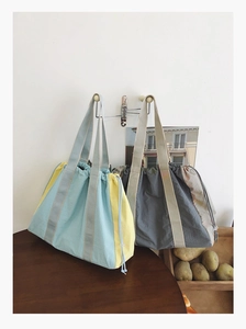 Detail of drawstring tote bag with dual shoulder straps and durable canvas texture