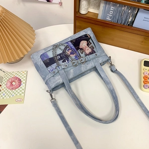 Detail der hellblauen Denim-Ita-Bag mit transparentem Sichtfenster und Metallkette