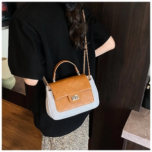 Detail showing contrast stitching and silver twist lock on quilted flap crossbody bag