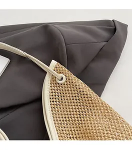 Close-up of handmade straw tote bag with white leather trim and silver metal hardware