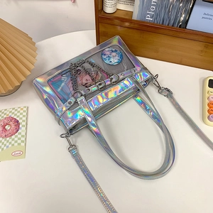 Detailansicht der schillernden Ita-Bag mit Silberketten und klarem Sichtfenster