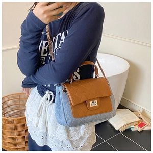 Detail of color-block crossbody bag with blue denim base and brown quilted leather flap