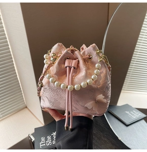 Close-up of pink jacquard bucket bag with pearl handle and 3D butterfly details