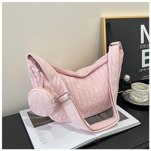 Detail of light pink pleated crossbody bag with matching round mini coin purse and silver buckle