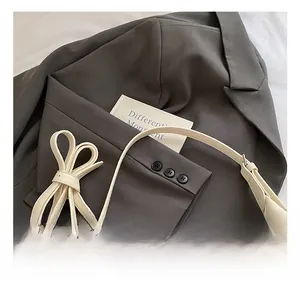 Gros plan du sac en cuir PU crème avec décoration nœud papillon et bandoulière réglable
