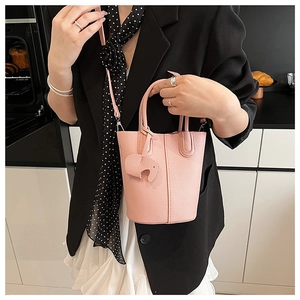 Pink lychee grain leather bucket bag with an elephant charm and thin crossbody strap