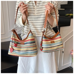 Détail du sac à bandoulière en paille tressée colorée avec sangle en cuir et fraise
