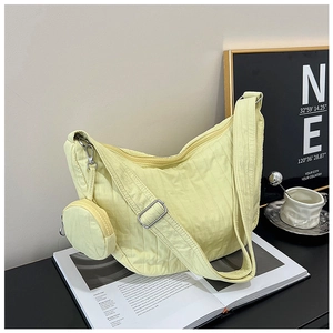 Detail of yellow quilted nylon crossbody bag with adjustable strap and mini round coin purse