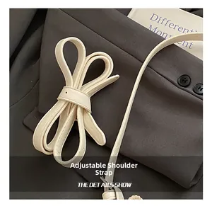 Détail de la bandoulière réglable en cuir crème et coutures précises du sac à bandoulière