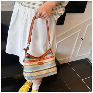 Détail du sac bandoulière en paille tissée à rayures multicolores et bandoulière en cuir