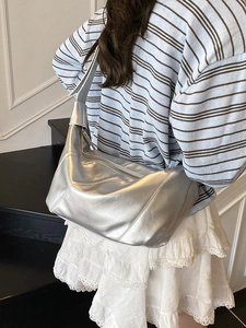 Grand sac hobo argenté métallisé à bandoulière large porté par un mannequin