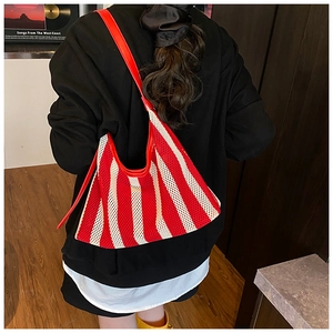 Détail du sac fourre-tout en résille à rayures rouges et blanches avec bandoulière en cuir