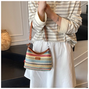 Détail d'un sac tissé arc-en-ciel avec rayures vives et bandoulière en cuir marron