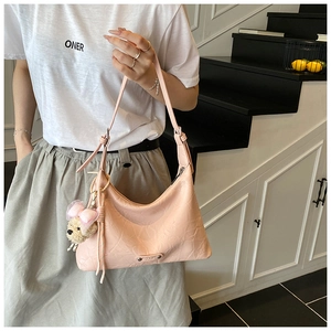 Détail du sac hobo rose avec texture cuir plissé et un porte-clés ourson mignon