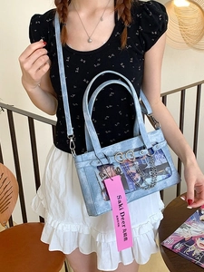 Hellblaue PU-Leder Ita Bag mit Klarsichtfenster und Herzanhängern am Modell präsentiert
