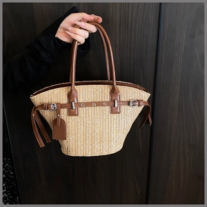 Detailed close-up of woven straw texture and premium brown leather straps on beach tote