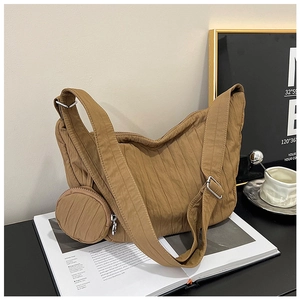 Detailed macro view of the brown pleated texture fabric on a large crossbody dumpling bag